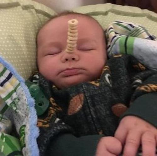 У американских папочек новый челлендж в соцсетях: кто сложит на своем спящем маленьком ребенке самую высокую башенку из сладких сахарных колечек.