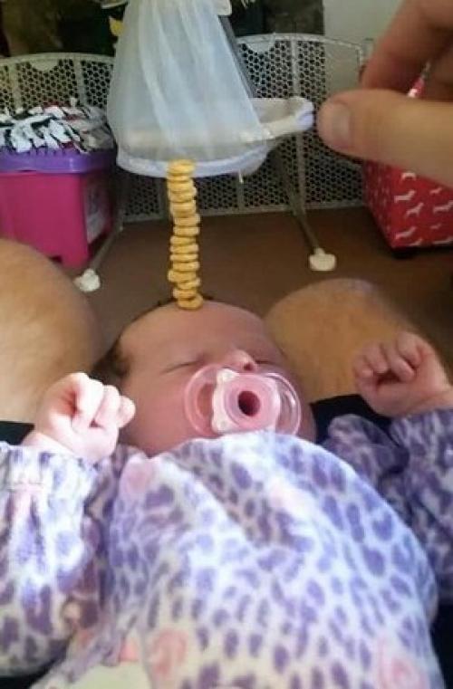 У американских папочек новый челлендж в соцсетях: кто сложит на своем спящем маленьком ребенке самую высокую башенку из сладких сахарных колечек. 05